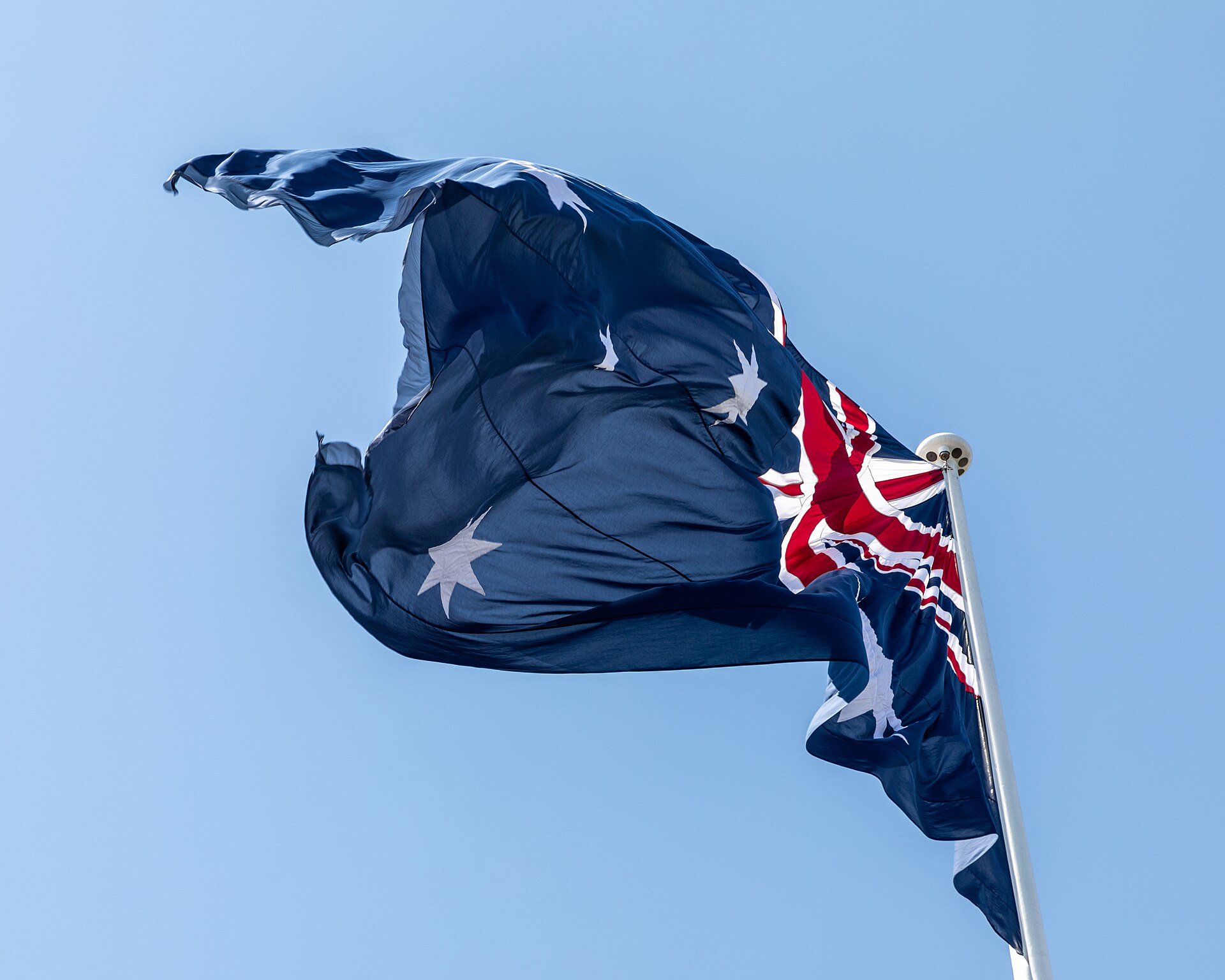 Flag at Darling Harbour, Sydney, New South Wales, AustraliaDarling Harbour in Sydney is located on the eastern edge of the city center and has a long and varied history. Originally, the area was a natural bay and river connection used by the Gadigal and Eora communities. In the 19th century, the harbour developed into an important hub for goods, shipping, and naval activities, with customs facilities, shipyards, and warehouses dominating the landscape. Through land reclamation and redevelopment, Darling Harbour gradually transformed from a working port to a leisure, recreation, and exhibition district.In the 1980s, a strategic shift took place: urban redevelopment, new infrastructure, and major events led to increased use as an urban leisure and MICE location. With the Bicentennial in 1988, the area was redesigned, and museums, convention centers, restaurants, and green spaces were created. Today, Darling Harbour combines history with science, culture, and leisure and remains a vibrant attraction in the heart of Sydney.