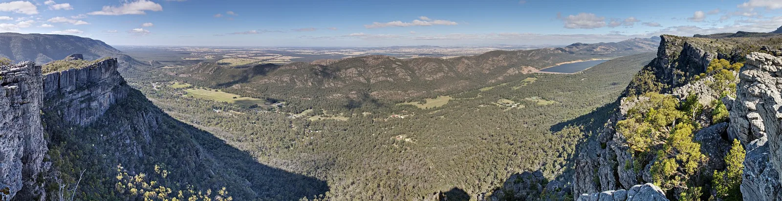 A 180 ~degree panoramic view from The Pinnacle in the Grampians National Park in Victoria, Australia. The town of Halls Gap is visible in the valley. This is an exposure blended image of 27 images (3 exposures of 9 frames taken in portrait format) taken by myself with a Canon 5D and 24-105mm F/4L IS lens.