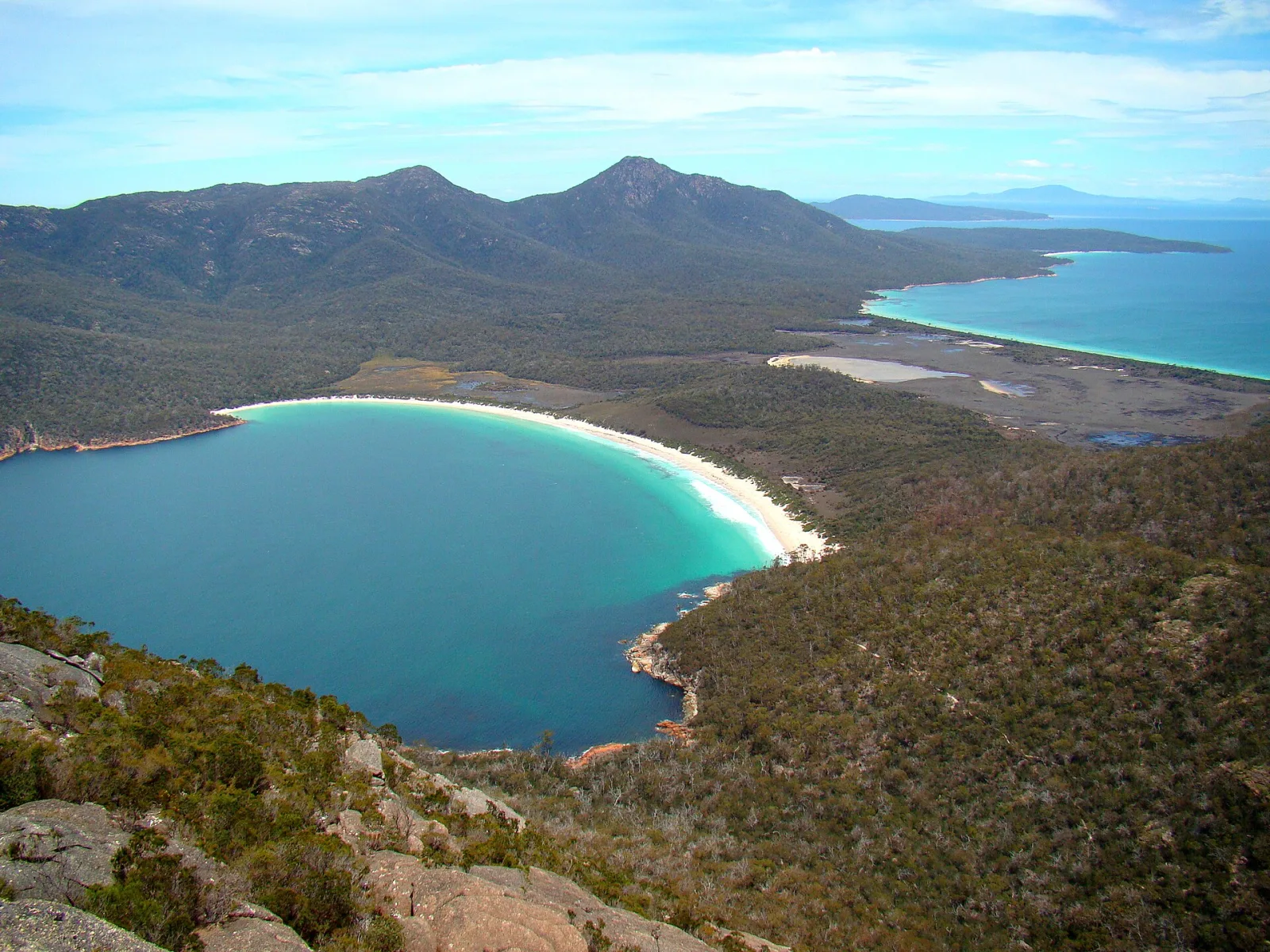 Wineglass Bay to the left and Promise Bay across the plains to the left, on the Freycinet Peninsula in Freycinet National Park on the Tasmanian east coast. Photo taken from Mount Amos.